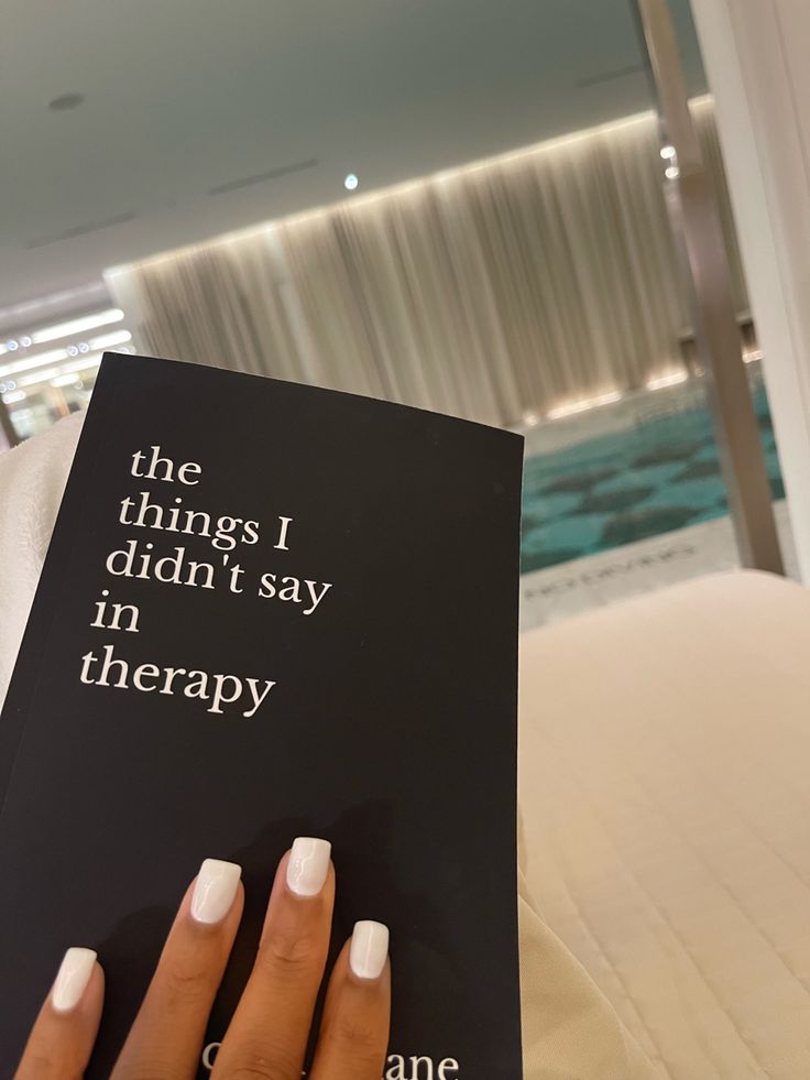 a woman's hand holding a book that says the things i didn't say in therapy