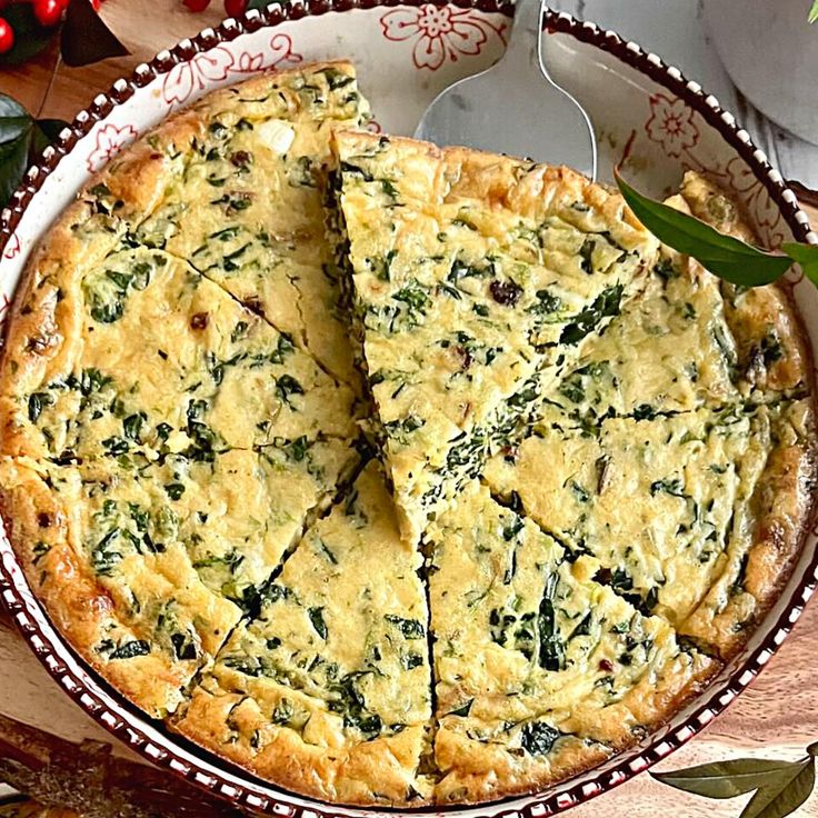 a quiche with cheese and spinach is cut into slices on a platter