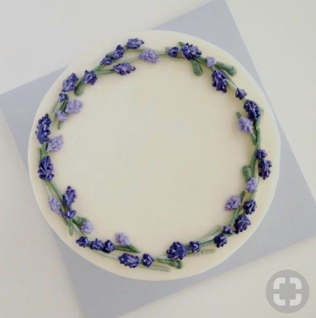 a cake decorated with purple flowers and green leaves