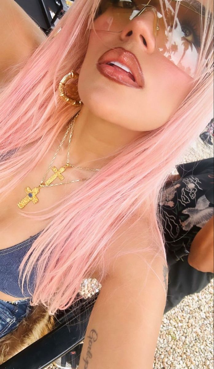 a woman with pink hair and sunglasses on