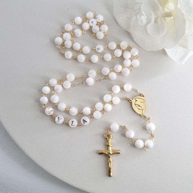 This Personalized Rosary, is ideal as a Baptism gift for a little girl or baby boy or as a gift for a special occasion. It is expertly handcrafted in a traditional style with a contemporary twist utilizing genuine Mother of pearl stone and gold-plated brass wire, which not only gives a touch of nature but also tenderness. The letter beads on the Rosary are also handmade from genuine mother of pearl, and the length is perfect to worn as a dainty Rosary necklace for women. *MATCHING ROSARY BRACELE Mother's Day Gift Rosary With 8mm Beads, White Spiritual Jewelry With Custom Name, Custom Name White Spiritual Jewelry, Handmade Adjustable Rosary For First Communion, Customizable White Adjustable Rosary Bracelet, Handmade White Rosary Bracelet For Wedding, Adjustable Round Rosary As Gift, Round Polished Bead Rosary As Gift, Polished Round Beads Rosary As Gift