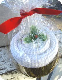 a cupcake wrapped in plastic with a red bow