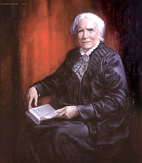 an old woman is sitting and holding a book in her hands while looking at the camera