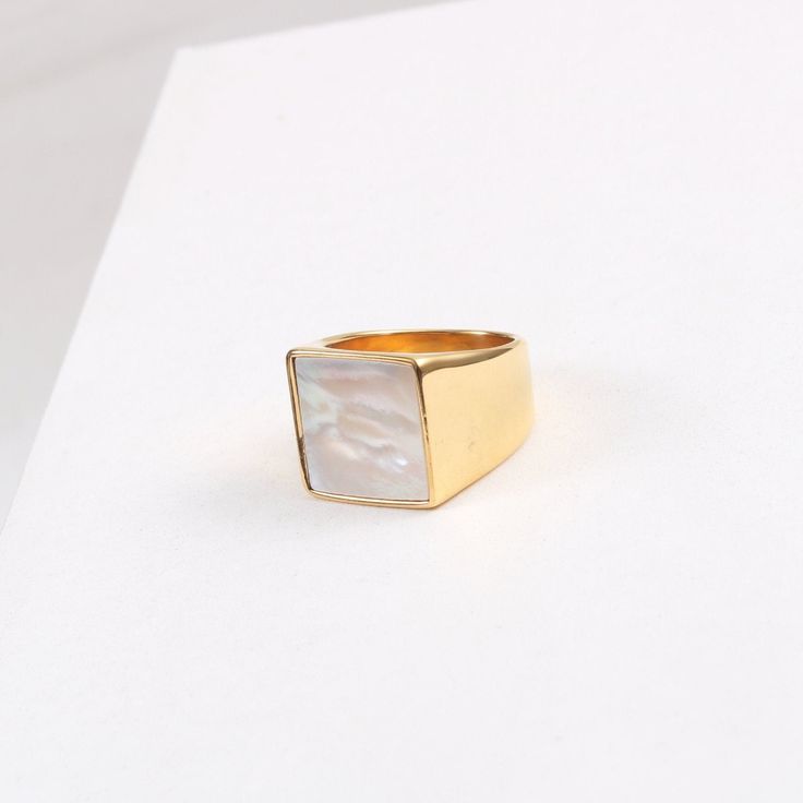 This 18K Gold Plated Large Square Mother-of-Pearl Ring is a luxurious, statement-making piece. Featuring a chunky gold band with both mother-of-pearl and black onyx accents, it's the perfect unique gift for any special occasion. This signet ring is also an ideal stacking ring for daily wear. [MATERIAL]: Yellow brass with real 18k gold plated. Our ring will not tarnish or turn green.[PLEASE NOTE]: Each shell color is unique so the shade and color might slightly vary. Elegant Gold Rings With Mother Of Pearl, Gold Mother Of Pearl Rings For Anniversary, Gold Mother Of Pearl Anniversary Rings, Gold Mother Of Pearl Ring For Gift, Gold Mother Of Pearl Ring As A Gift, Modern Gold Jewelry With Mother Of Pearl, Mother Of Pearl Ring, Clean Sterling Silver, Shell Color