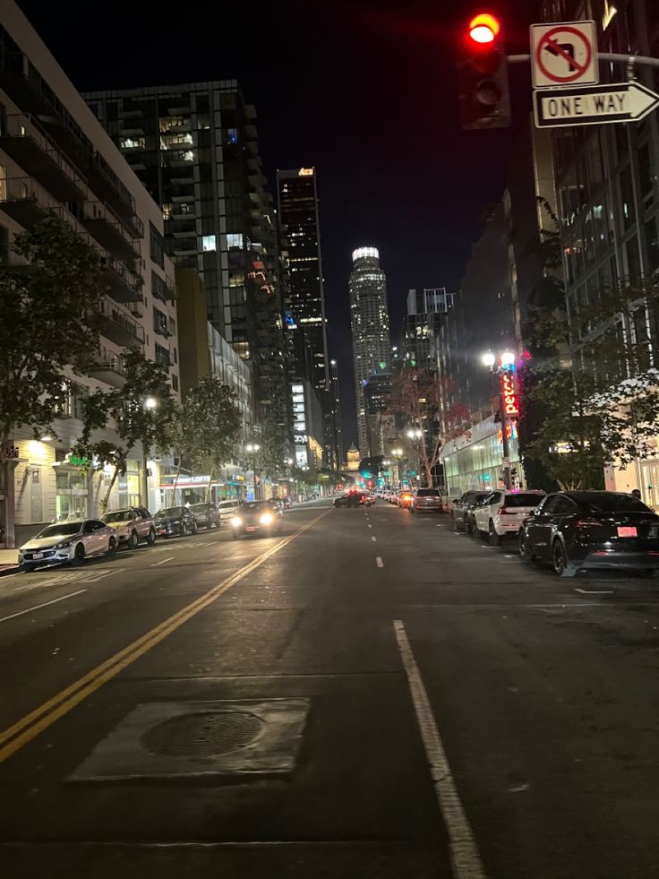 an empty city street at night with traffic lights