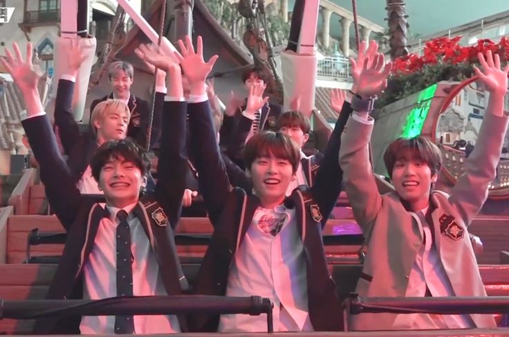 group of young boys in school uniforms waving