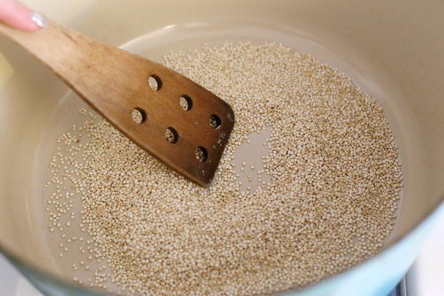 a wooden spatula in a pan filled with grains