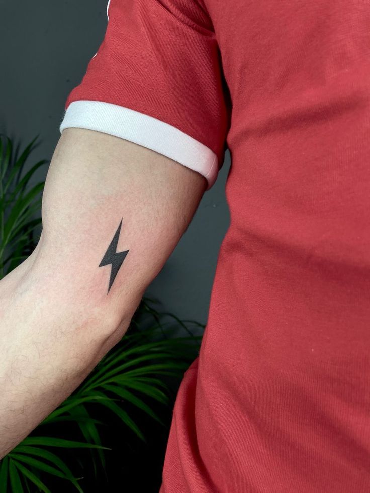 a man's arm with a lightning tattoo on the left side of his arm