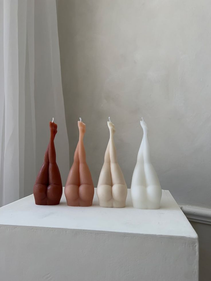 three different colored vases sitting on top of a white table next to a window