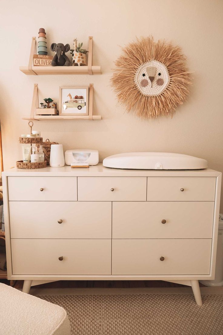 a baby's room with a crib, dresser and shelves on the wall