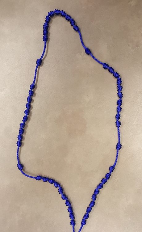 a blue beaded necklace on a white surface