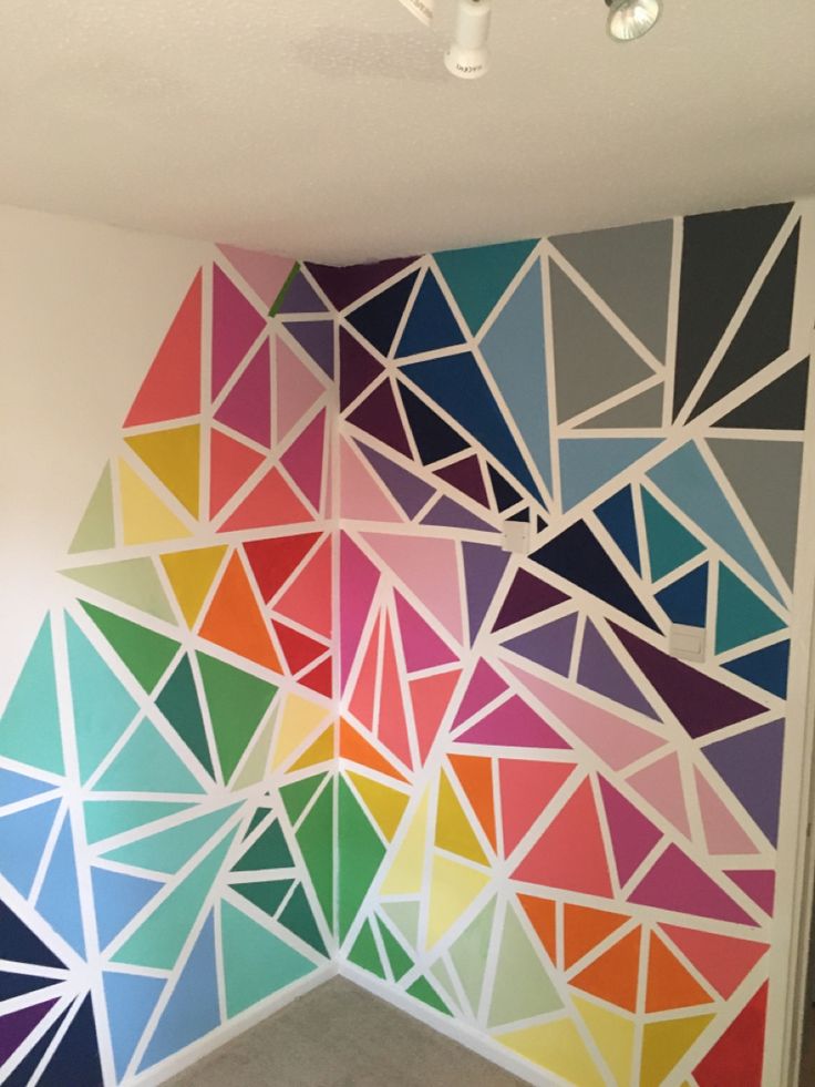 a colorful wall with geometric shapes painted on it's sides and the ceiling is white