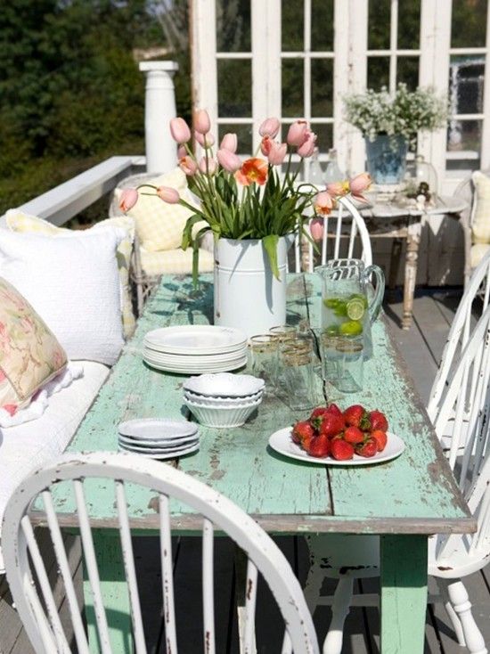 an image of a table with flowers and plates on it in front of a window