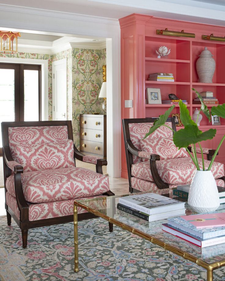 a living room filled with furniture and a pink book case on top of a coffee table