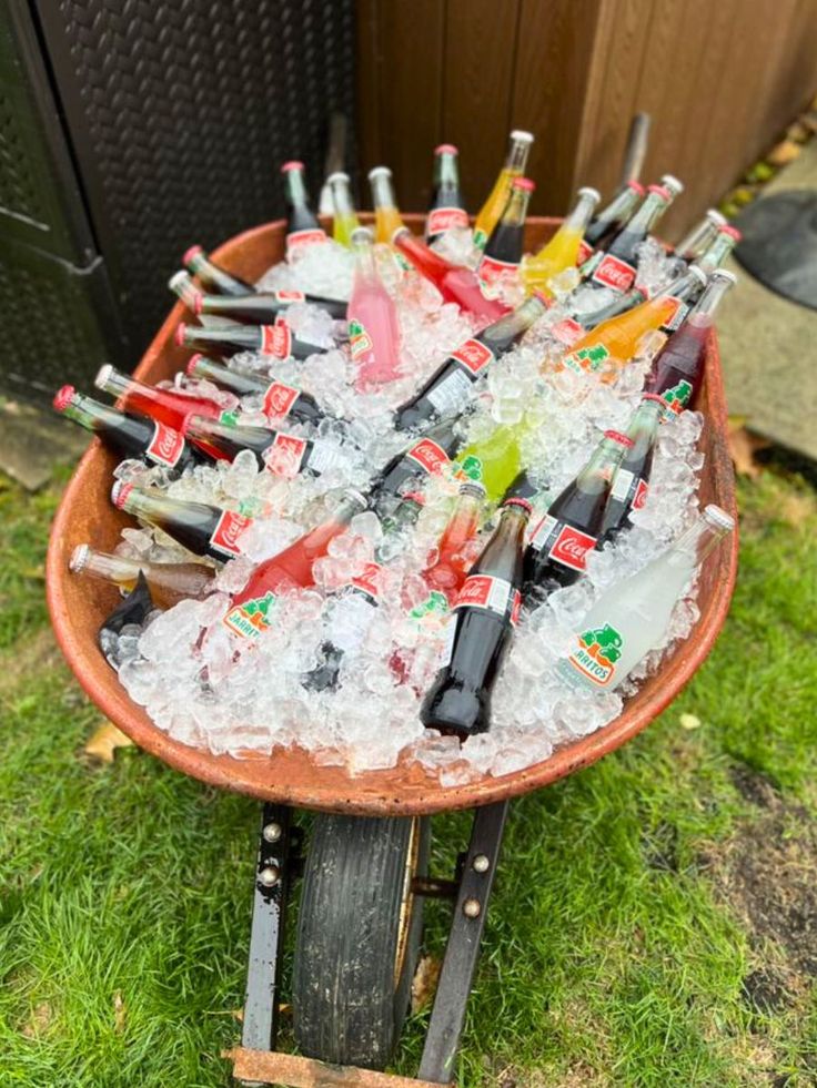 a wheelbarrow filled with lots of bottles and ice