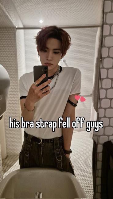 a person standing in front of a toilet holding a cell phone with the caption, his bra strap fell off guys