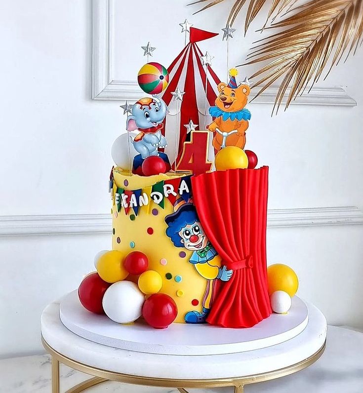 an image of a cake with clowns on top and circus tent in the background