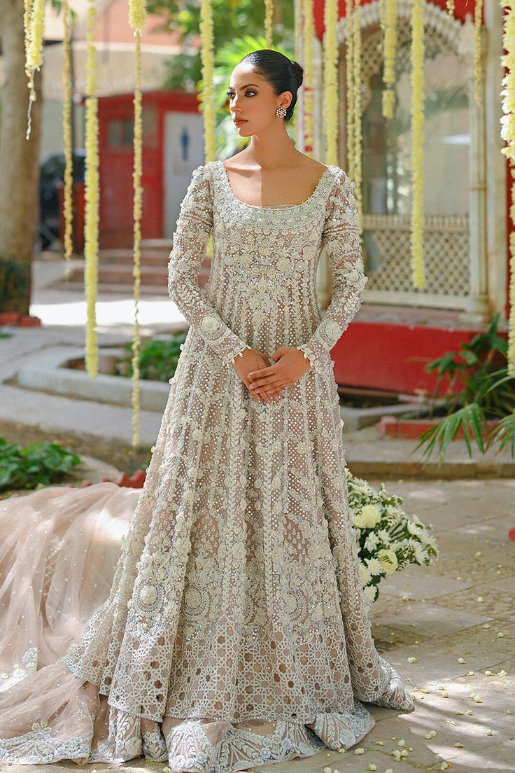 A pale pink hued tulle peshwas and veil is delicately embroidered with handworked resham, 3d floral motifs, and intricate cutwork details at the hem. The tissue brocade lehnga has a tulle layer with a composed worked border. Eid Wedding Dress With Sheer Dupatta, Eid Ceremony Wedding Dress With Sheer Dupatta, Elegant Floral Embroidered Dupatta For Ceremony, Elegant Floral Embroidery Dupatta For Ceremony, Anarkali Wedding Dress With Dupatta In Organza, Anarkali Organza Wedding Dress With Dupatta, Resham Embroidered Saree Wedding Dress For Reception, Designer Intricate Embroidery Wedding Dress For Eid, Designer Wedding Dress With Resham Embroidery For Eid