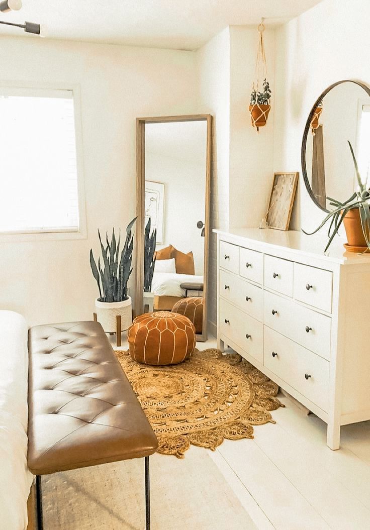 a bedroom with white furniture and plants on the dresser next to the bed in front of it