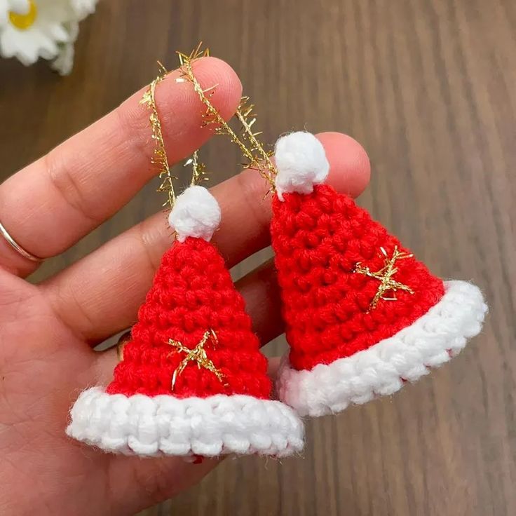 someone is holding two tiny christmas hats