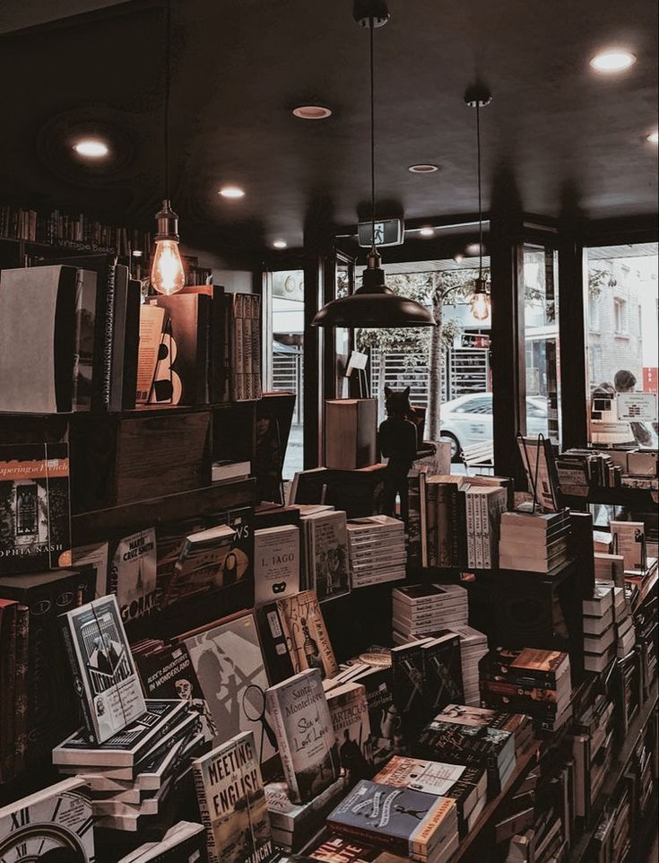 a room filled with lots of books next to a window