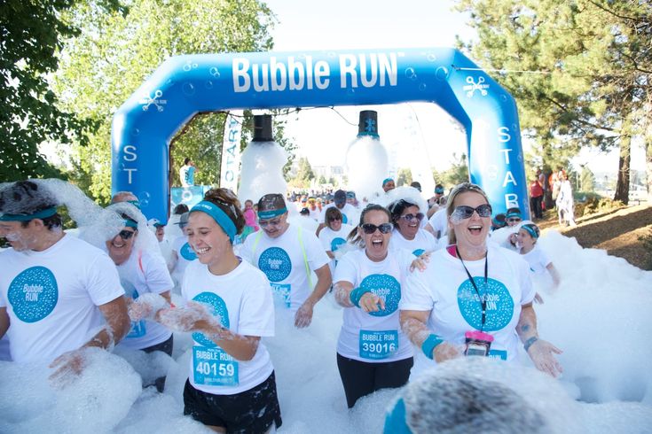 a group of people that are running in the snow with some kind of foam on them