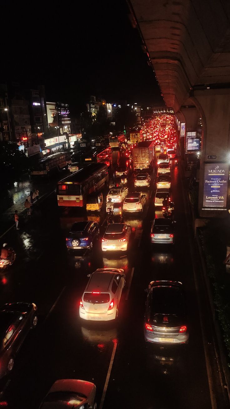 many cars are lined up on the side of the road at night in heavy traffic