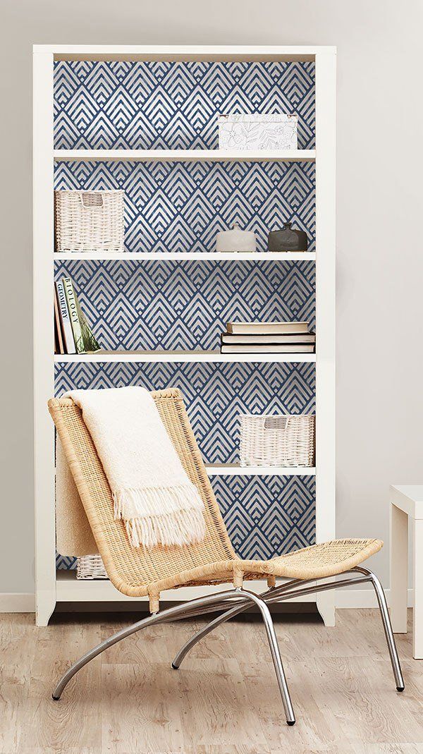 a chair sitting in front of a book shelf