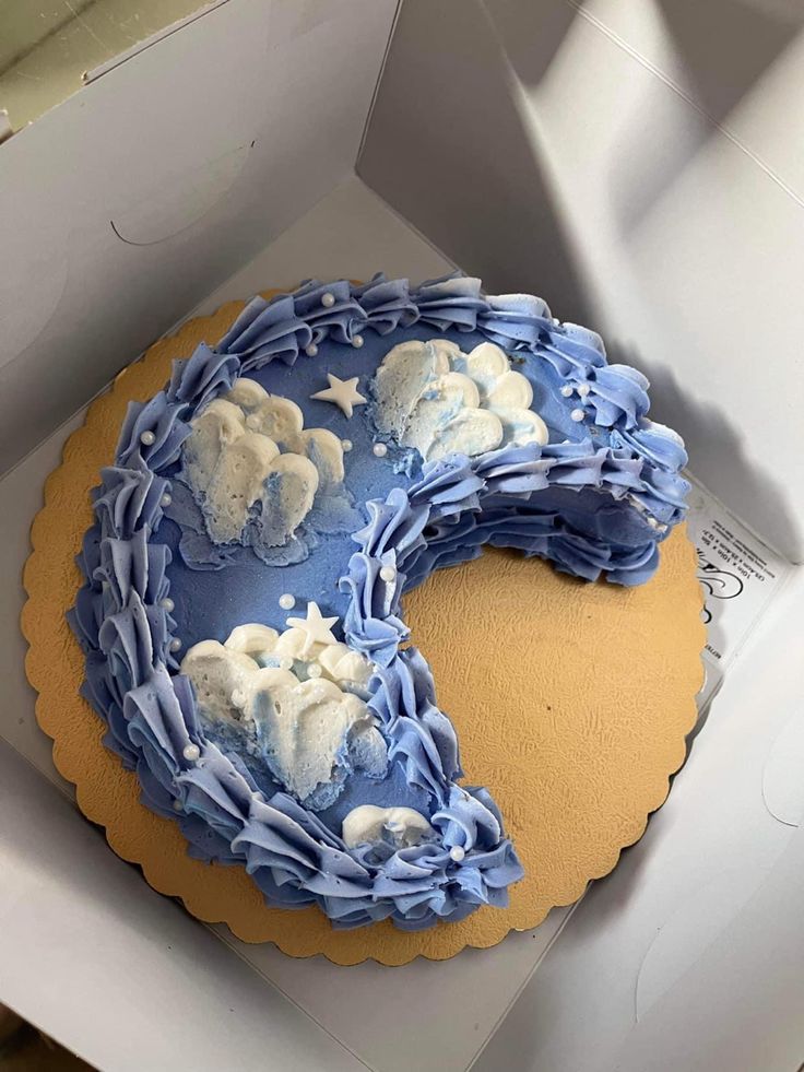 a blue and yellow cake in a box with white frosting on it's edges