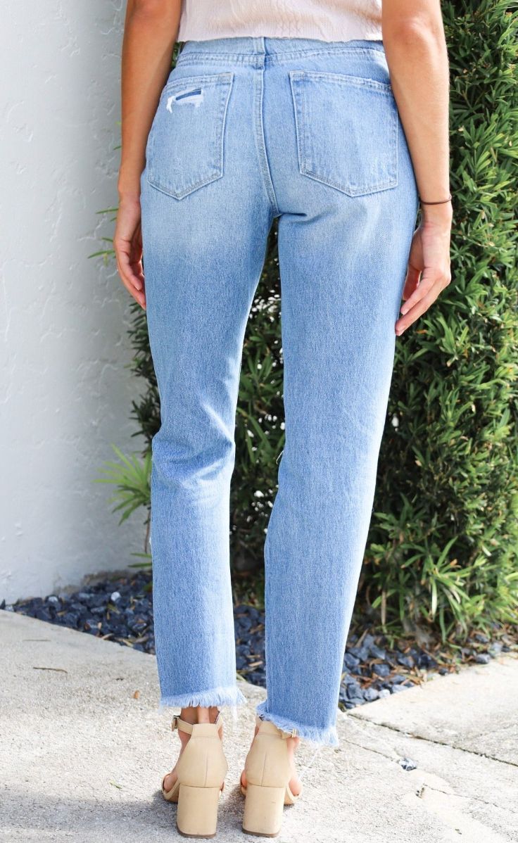 The Distressed Raw Hem Mom Jeans are a chic blend of vintage and contemporary fashion. With their high-rise waist, they offer a comfortable and flattering fit that harks back to the iconic mom jean style. The distressed and raw hem detailing adds a touch of casual, edgy charm, making these jeans a versatile choice for creating a fashion-forward look that exudes confidence and personality. -Mom style jean -High rise -Rise: 11 1/8" -Inseam: 27" -Leg opening: 13" -Distressed detail -Raw hem -100% c Dark Wash Mom Fit Jeans For Spring, Spring Dark Wash Mom Fit Jeans, Everyday High Rise Distressed Jeans, High Rise Cropped Jeans In Medium Wash, Distressed Mid-rise Cropped Jeans For Everyday, Ripped Mid-rise Cropped Jeans For Everyday Wear, Everyday Ripped Mid-rise Cropped Jeans, Distressed Mid-rise Bottoms For Everyday, Everyday Distressed Mid-rise Bottoms