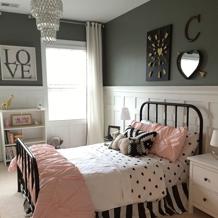 a bed room with a neatly made bed and a chandelier hanging from the ceiling