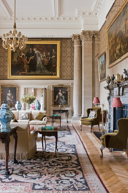 a living room with couches, chairs and paintings on the wall in it's center