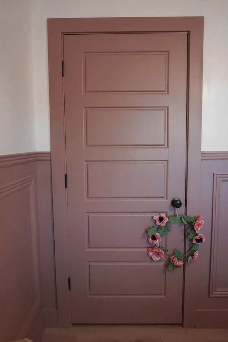 a door with a wreath hanging on it's side next to two doors in a room