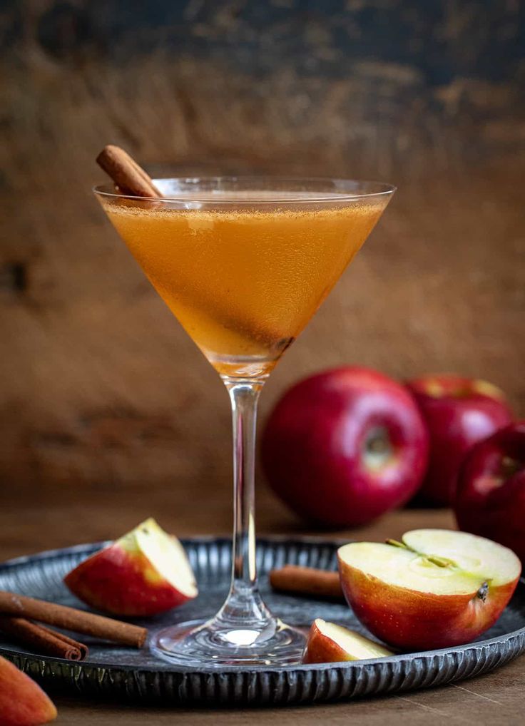 an apple cider sits on a plate with cinnamon sticks and apples in the background