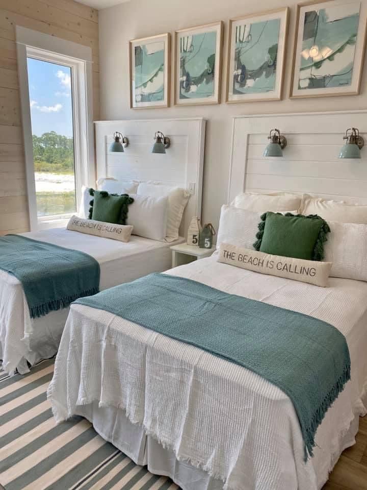 two beds in a room with pictures on the wall above them and one bed has green pillows