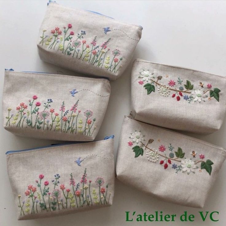 four embroidered pouches with flowers on them