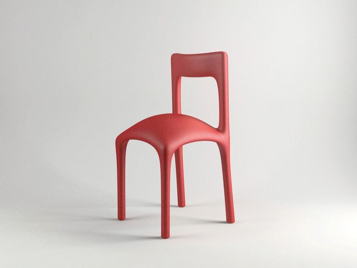 a red plastic chair sitting on top of a white floor in front of a wall