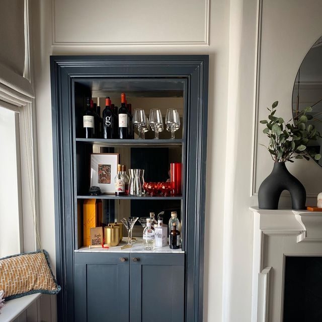 a blue bookcase filled with bottles and glasses