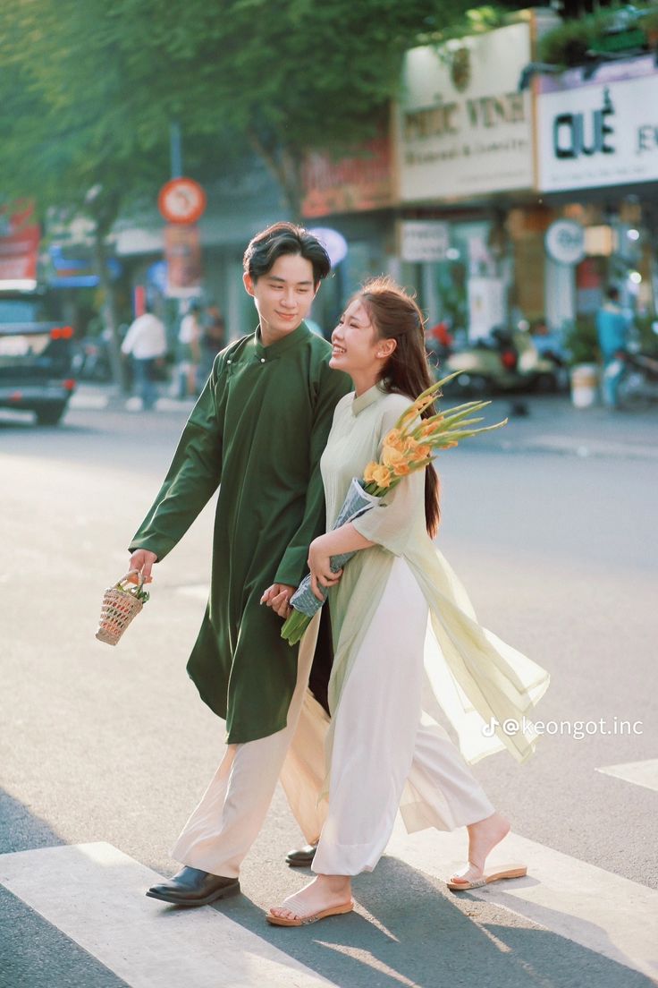 a man and woman walking down the street holding hands with each other while carrying flowers