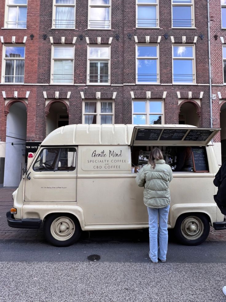 a woman standing in front of a food truck