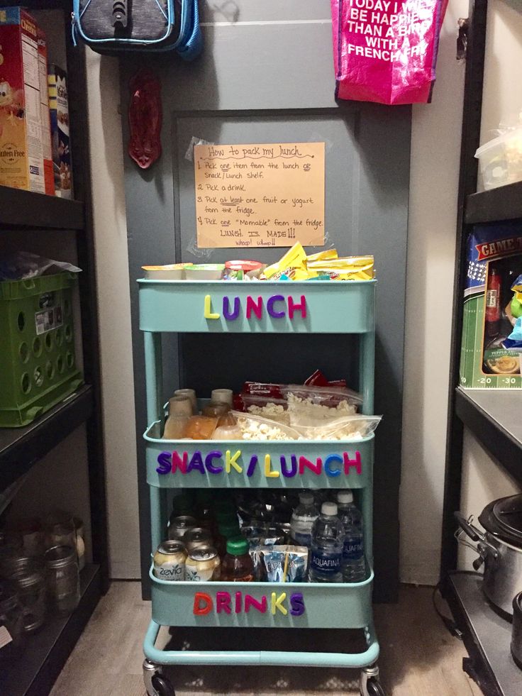 a blue cart filled with lots of food next to a wall covered in magnets