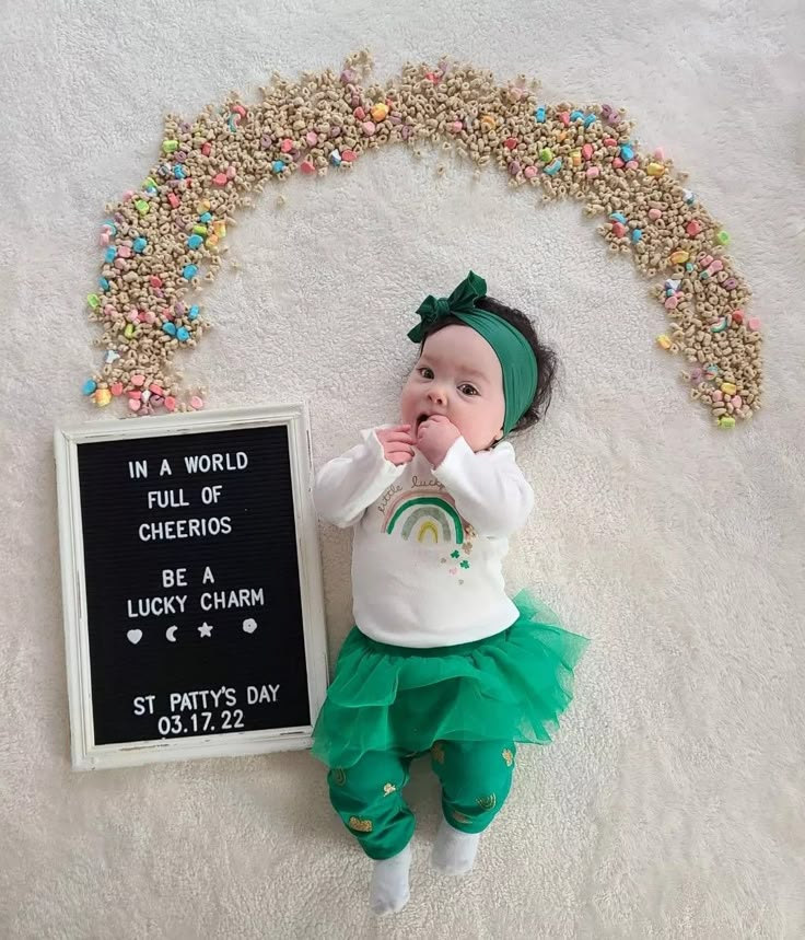 a baby is laying on the floor next to a sign