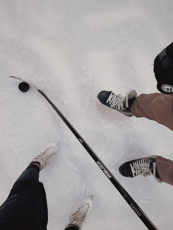 two people standing next to each other on an ice rink