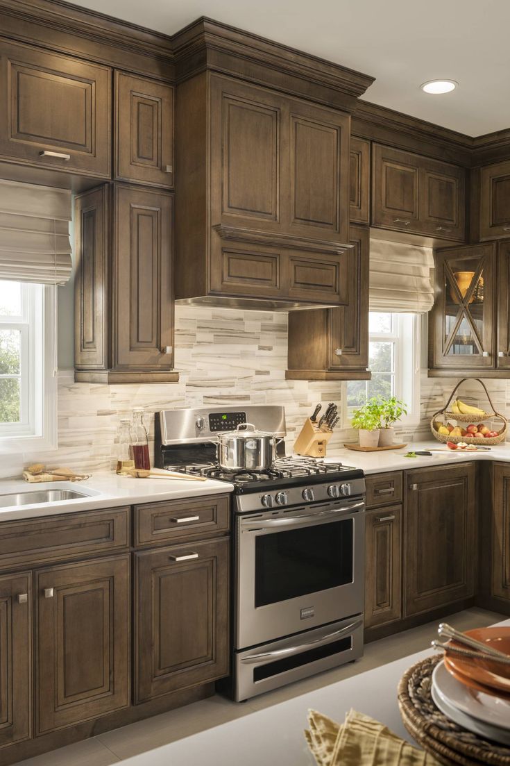 a kitchen filled with lots of wooden cabinets and counter top space next to a window