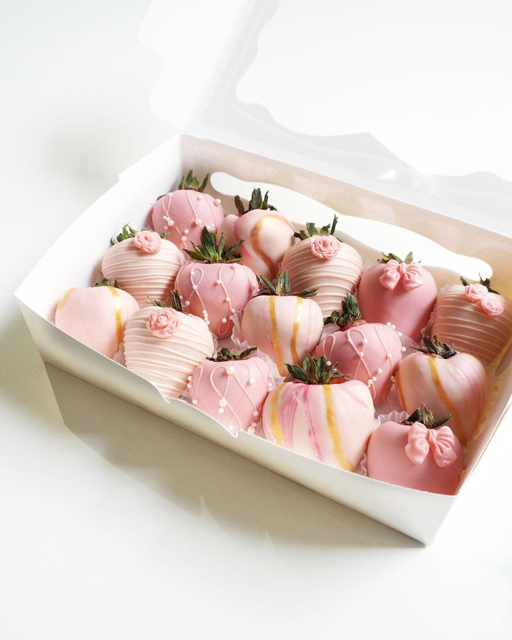 a box filled with pink and white chocolate covered strawberries