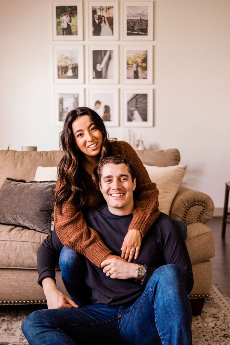 a man sitting on top of a woman's lap in front of a couch