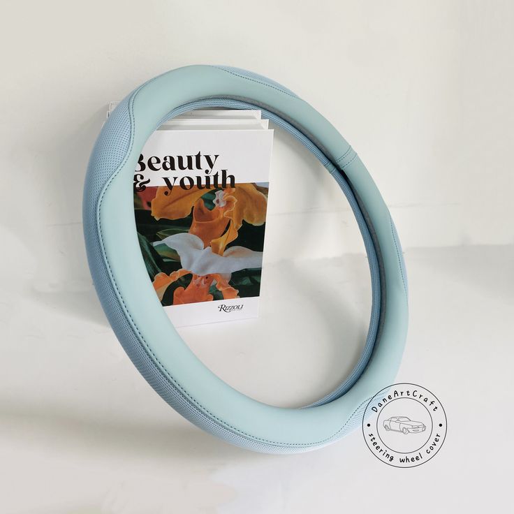 a book sitting on top of a table next to a blue ring shaped object with a magazine in it