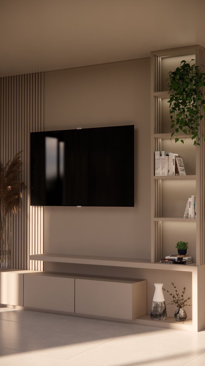 an empty living room with a large television on the wall and bookshelves in front of it