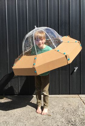 a young boy holding an open cardboard box with a clear cover on it's head