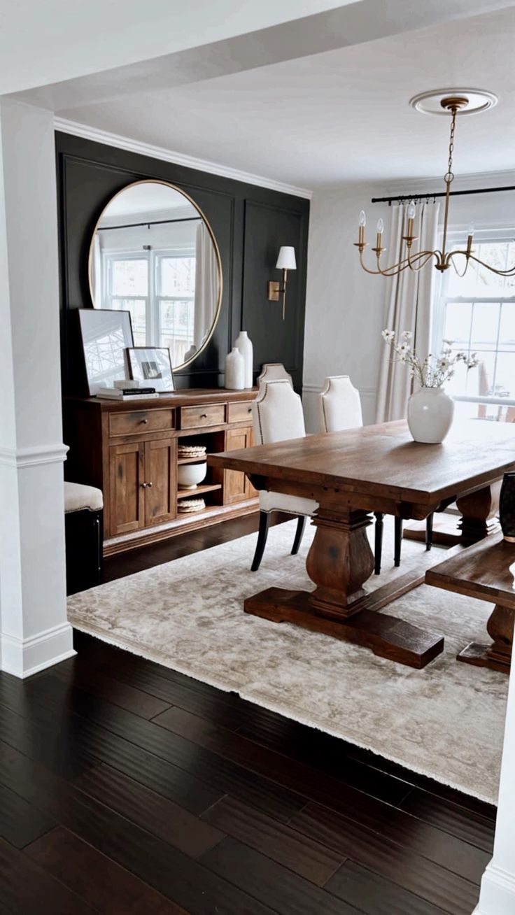 a dining room table and chairs in front of a large mirror with a chandelier